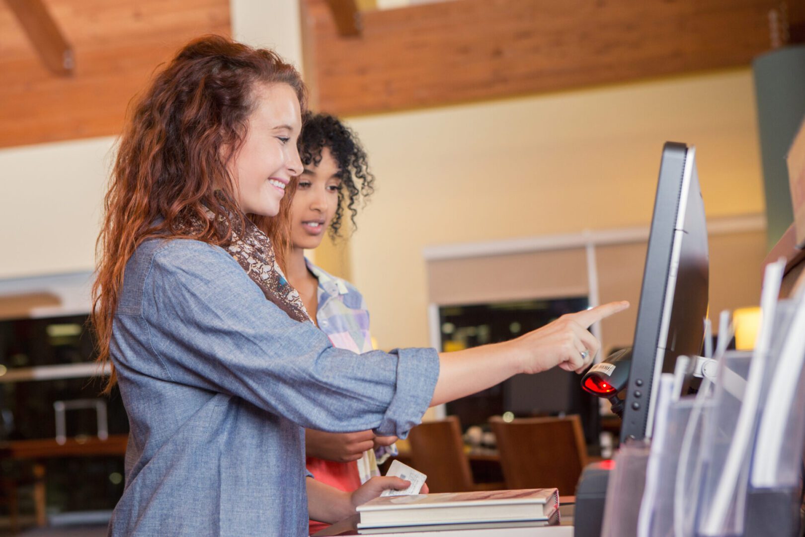 Women using library self-service kiosk