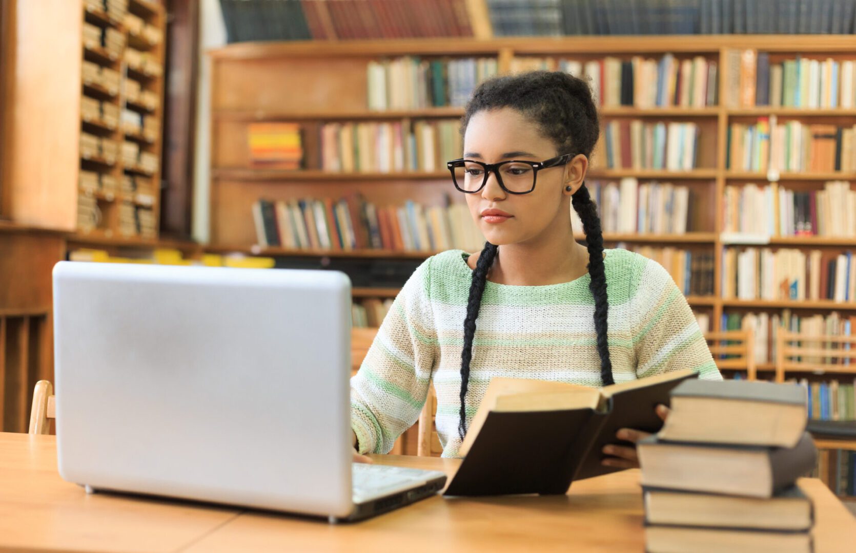 Student studying in library with laptop